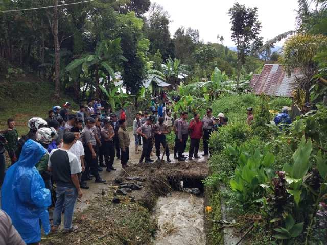 Warga dan pihak kepolisian melakukan pencarian korban di lokasi kejadian.